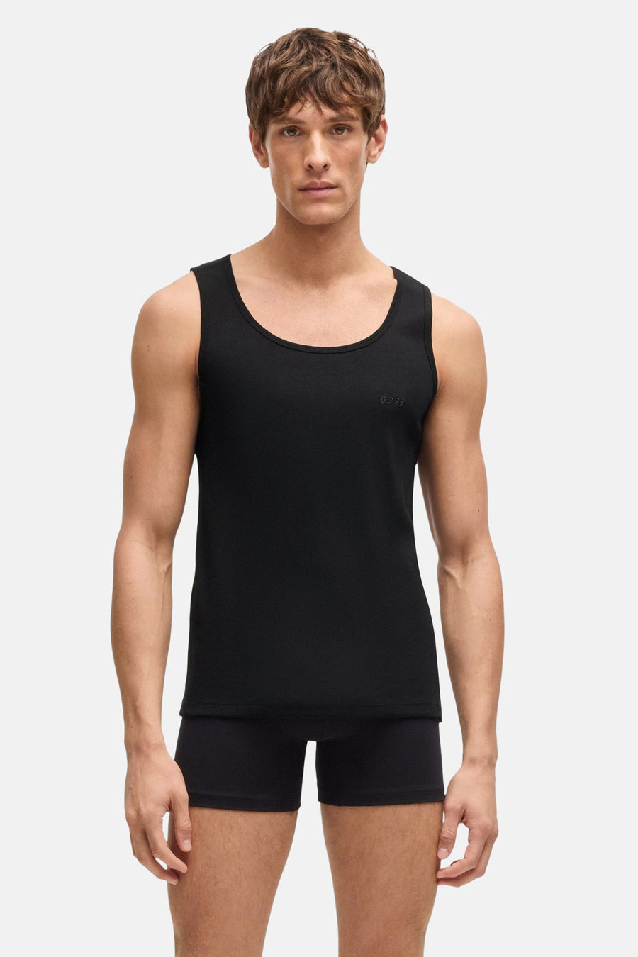 Débardeur noir de BOSS ORANGE, porté avec un boxer assorti sur fond clair.