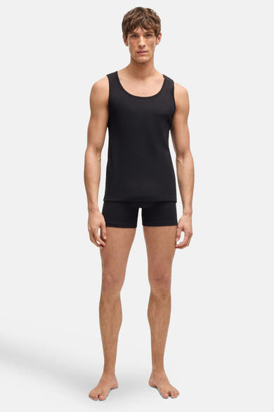 T-shirt débardeur noir de BOSS, porté avec un caleçon noir uni, sur fond blanc.