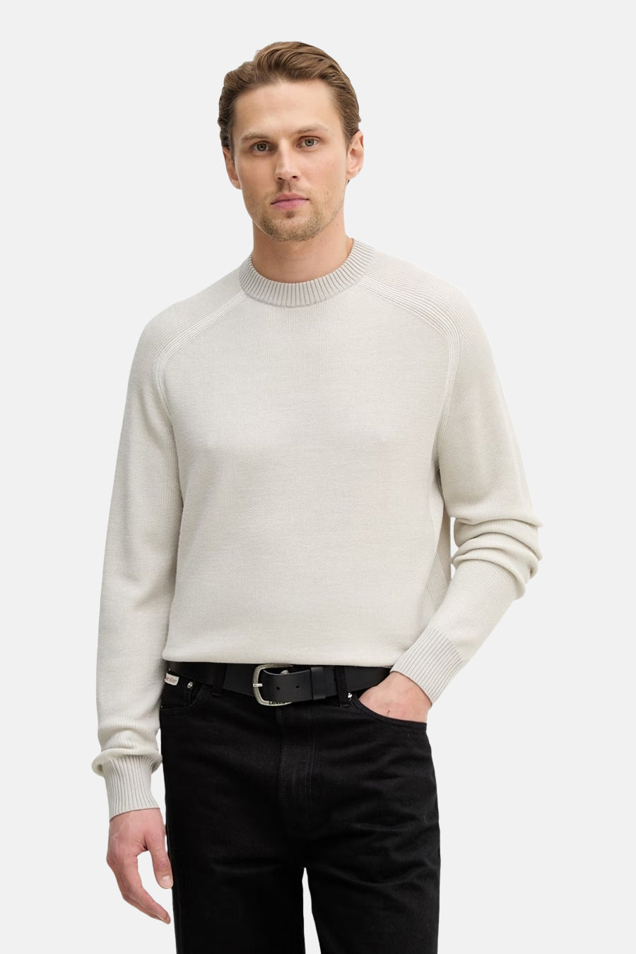 Pull col rond gris de BOSS ORANGE, porté avec un pantalon noir et une ceinture en cuir.