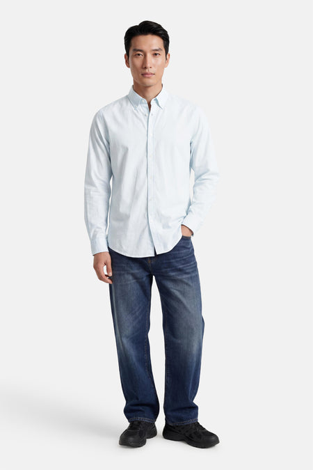 Chemise turquoise de BOSS ORANGE à manches longues et col boutonné, portée avec un jean et des baskets.