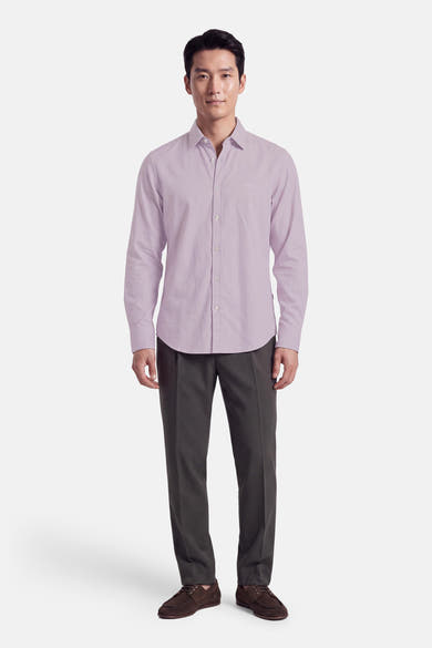 Chemise à manches longues violette par BOSS ORANGE, boutonnée, coupe ajustée, portée avec pantalon gris et chaussures marron, vue de face.