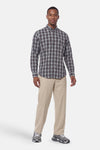 Grey plaid long-sleeve shirt by BOSS, featuring classic button-down front and chest logo, worn with beige trousers and grey sneakers in full-length lifestyle view.