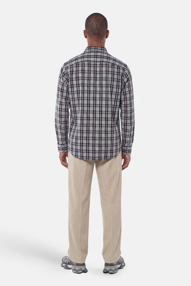 Grey plaid long-sleeve shirt back view, featuring dark grid pattern and buttoned cuffs, worn with beige trousers and grey sneakers.