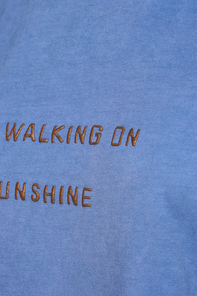 T-shirt bleu à manches courtes de MORE & MORE avec l'inscription « walking on sunshine » en lettres dorées.

