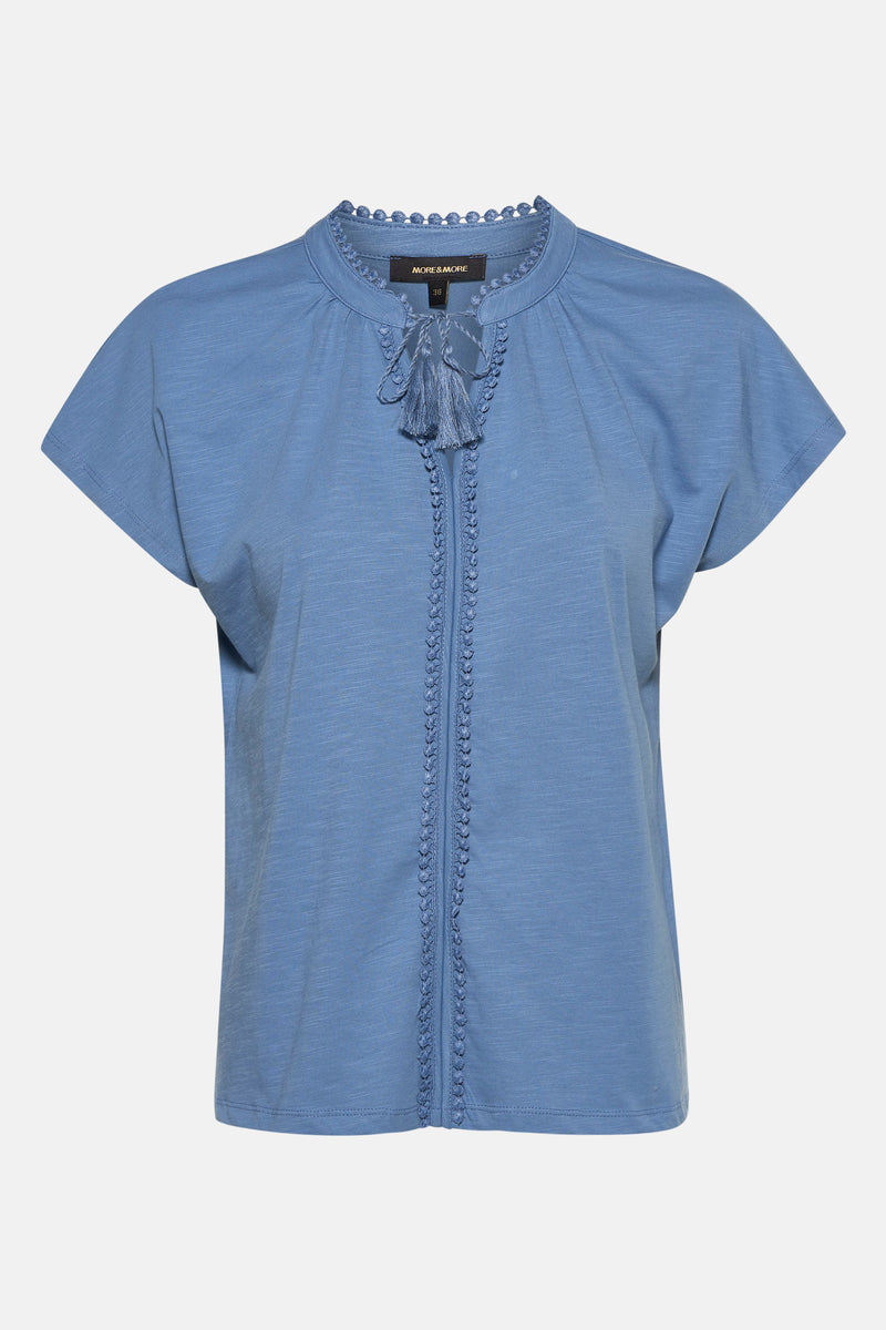 T-shirt bleu à manches courtes de MORE & MORE, avec détails brodés et liens décoratifs à pompons.

