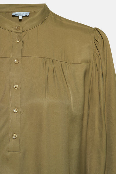 Blouse à manches longues verte de MORE & MORE, avec boutons et détails froncés.
