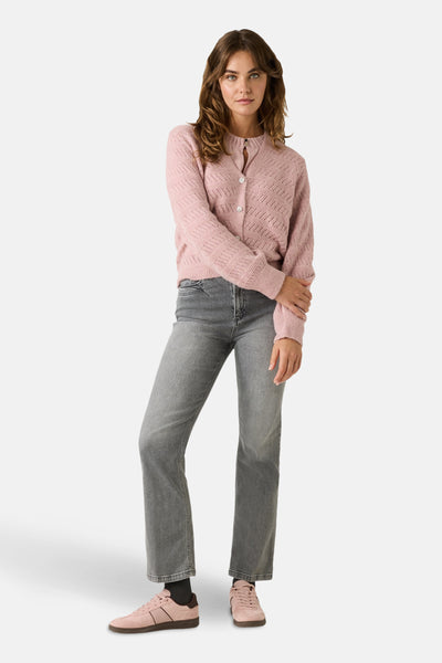 Cardigan rose à maille ajourée de MORE & MORE, porté avec un t-shirt rose, un jean gris et des chaussures de sport roses.