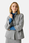 Grijze bodywarmer van MORE & MORE, gedragen met een blauwe coltrui en een bijpassende midirok.