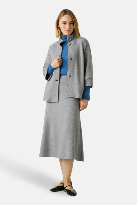 Gilet gris de MORE & MORE, porté avec un col roulé bleu et une jupe midi assortie.