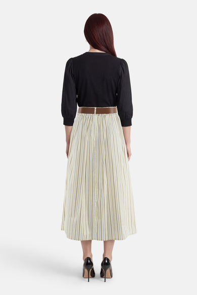 Jupe 3/4 jaune Terra di Siena à rayures verticales bleues et marron, portée avec une ceinture marron.
