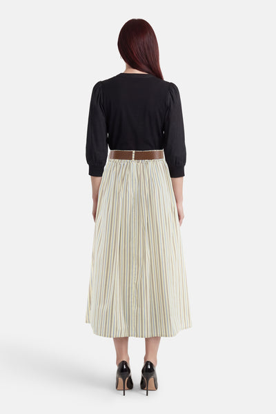 Jupe 3/4 jaune Terra di Siena à rayures verticales bleues et marron, portée avec une ceinture marron.