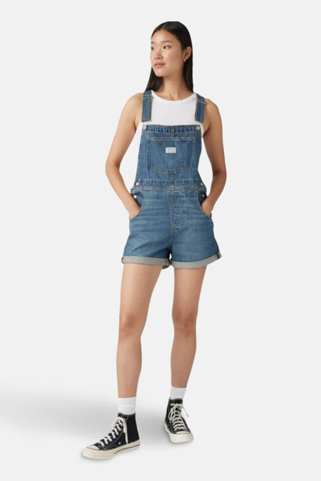 Denim tuinbroekshort in middieblauw van Levi's®, met schouderbandjes en opgestikte zakken.