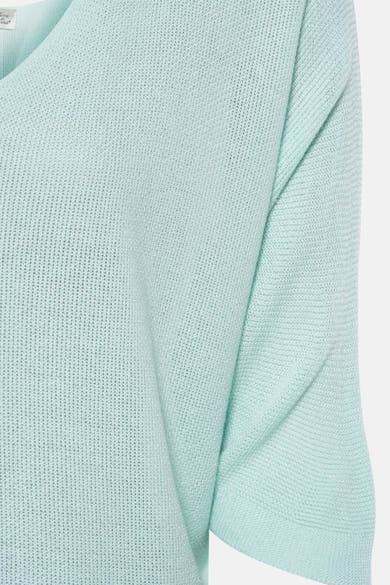 Gilet turquoise en maille de Terra di Siena, texture tricotée aérée, détail du décolleté.
