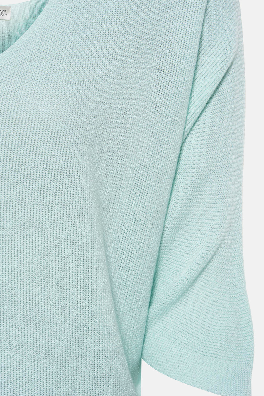 Gilet turquoise en maille de Terra di Siena, texture tricotée aérée, détail du décolleté.
