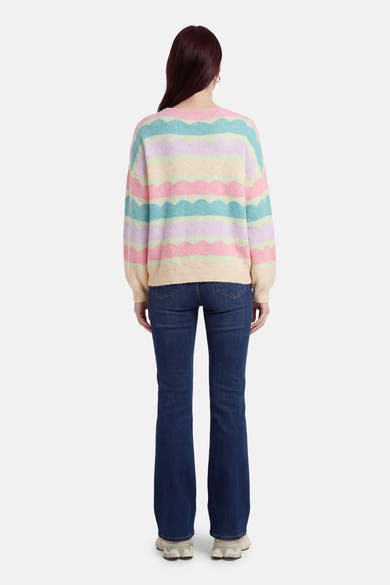 Multikleuren rondehals trui van Terra di Siena, met pastelkleurige golvende strepen, gedragen met een uitlopende jeans.