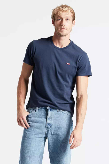 T-shirt bleu à manches courtes de Levi's, porté avec un jean bleu clair dans un style décontracté.
