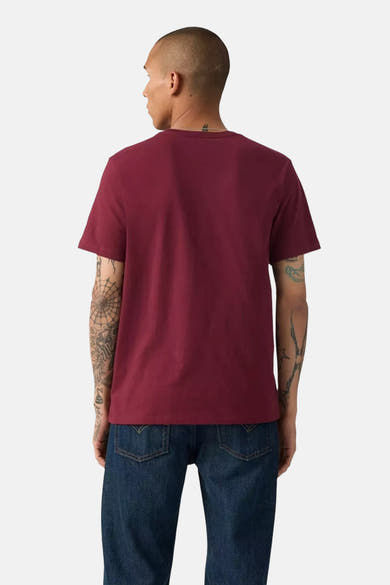 Bordeaux T-shirt met korte mouwen van Levi's, gedragen met een blauwe jeans, achtergezicht, man met getatoeëerde armen.