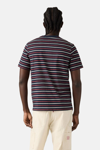 Blauw T-shirt met korte mouwen van Levi's® met bordeauxrode en witte strepen, gedragen met een beige broek.