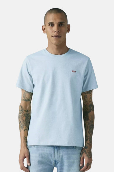 T-shirt bleu à manches courtes de Levi's, avec un logo rouge sur la poitrine et un jean clair.
