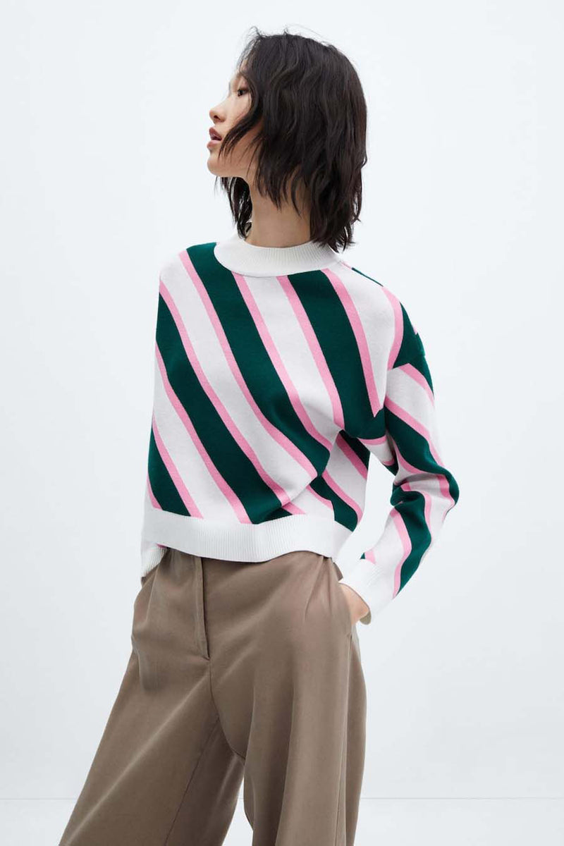 Multicolored striped knit sweater with white ribbed trim, side view on model wearing beige trousers
