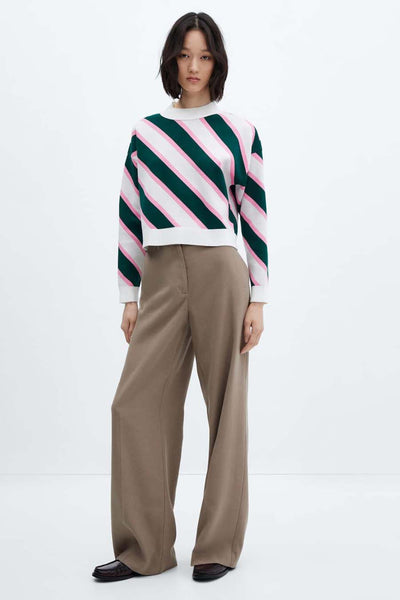 Multicolored striped crewneck sweater with green, pink, and white diagonal pattern, worn with wide-leg beige trousers and black loafers, front view.