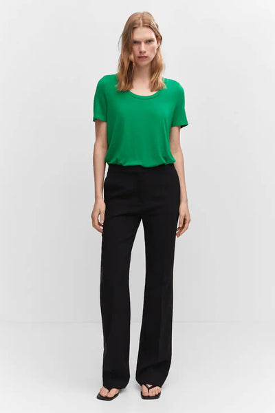 Green short-sleeve top with rounded neckline, worn with black wide-leg pants and flip-flops, front view.