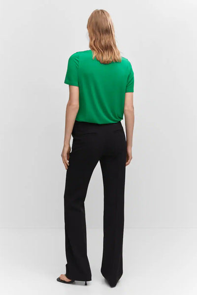 Green short-sleeve top with smooth fabric, back view, worn with black wide-leg trousers and black heels