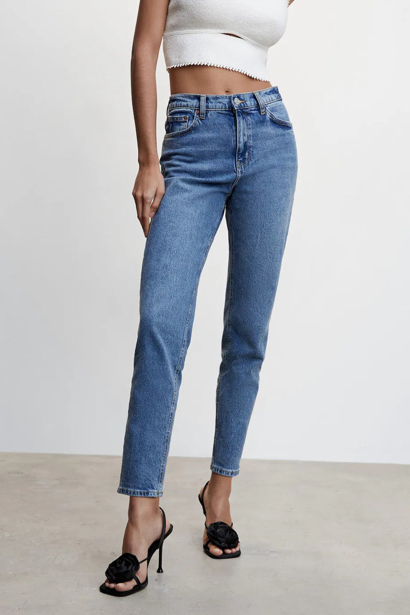 Jean Mom blauw van MANGO, rechte pasvorm, gedragen met een witte top en zwarte sandalen met hak.