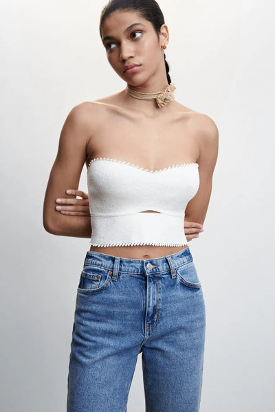 Blauwe mom jeans van MANGO, gedragen met een witte crop top en een gouden ketting.