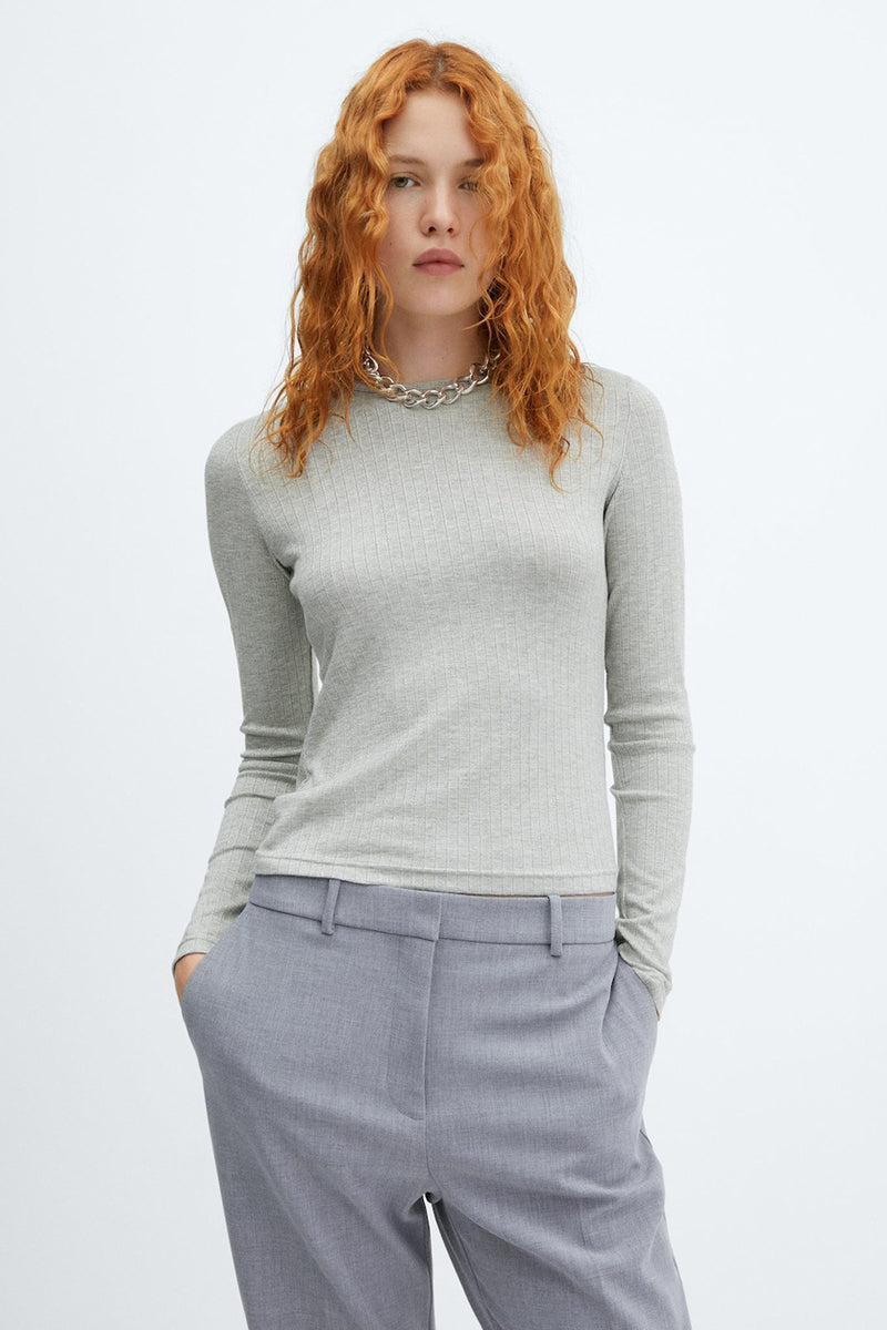 Top gris uni à manches longues de MANGO, porté avec un collier en argent et un pantalon tailleur assorti.