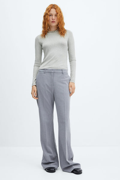 Top gris uni à manches longues de MANGO, porté avec un pantalon taille haute et un collier argenté.

