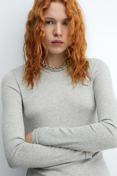 Grijze top met lange mouwen van MANGO, in geribbelde stof, gedragen met een zilveren schakelketting.