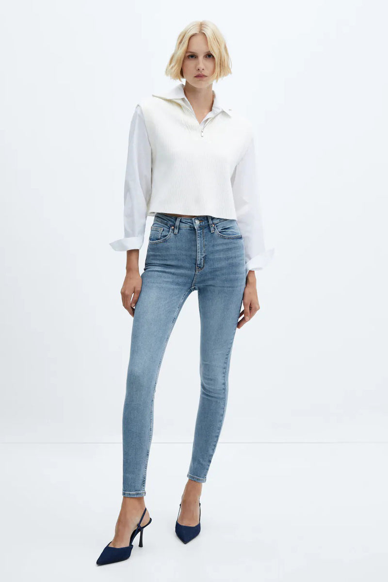 Light blue skinny jeans with high waist and slim fit, worn with white ribbed top and navy heels, full-length front view