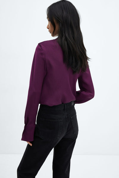 Mauve long-sleeve ribbed blouse from back view, worn with black jeans, side profile shot