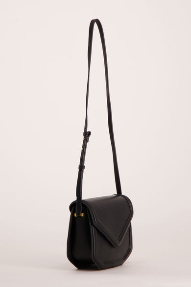 Black leather crossbody bag with flap closure and adjustable strap, side view
