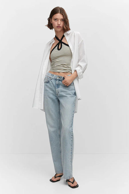 Blauwe rechte jeans van MANGO, met een relaxte pasvorm, gedragen met een gestreept topje en een wit overhemd.
