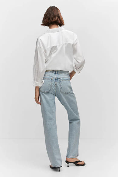 Jean droit bleu de MANGO, porté avec une chemise blanche et des talons aiguilles noirs, vue de dos.