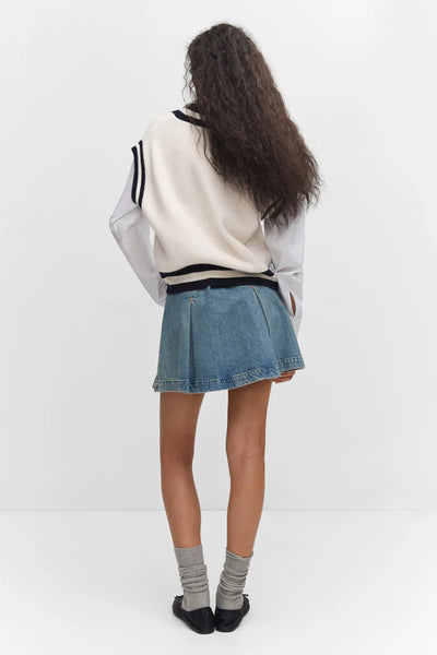 Beige ribbed tank top with black trim, back view, worn with denim skirt and gray socks