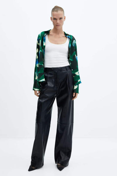 Green long-sleeve blouse with abstract leaf pattern, worn open over white tank top and black wide-leg pants, full-length front view