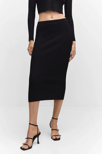 Black ribbed knit midi skirt with elastic waistband, front view on model wearing black crop top and strappy heels