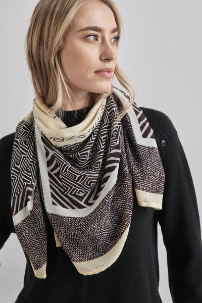 Foulard jaune de Street One avec motif géométrique marron et bordure écrue, porté avec un pull noir.
