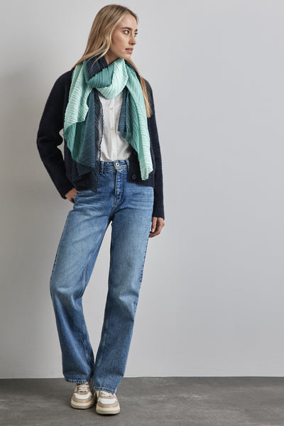 Foulard vert de chez Street One, plissé avec des nuances de bleu, porté avec une chemise blanche et un cardigan foncé.

