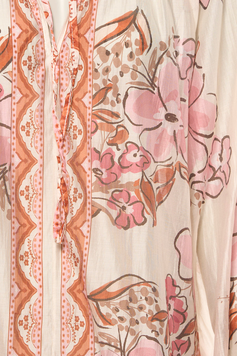 Multikleurige blouse van Terra di Siena, met roze bloemenprint en decoratieve sierdetails op een crèmekleurige achtergrond.
