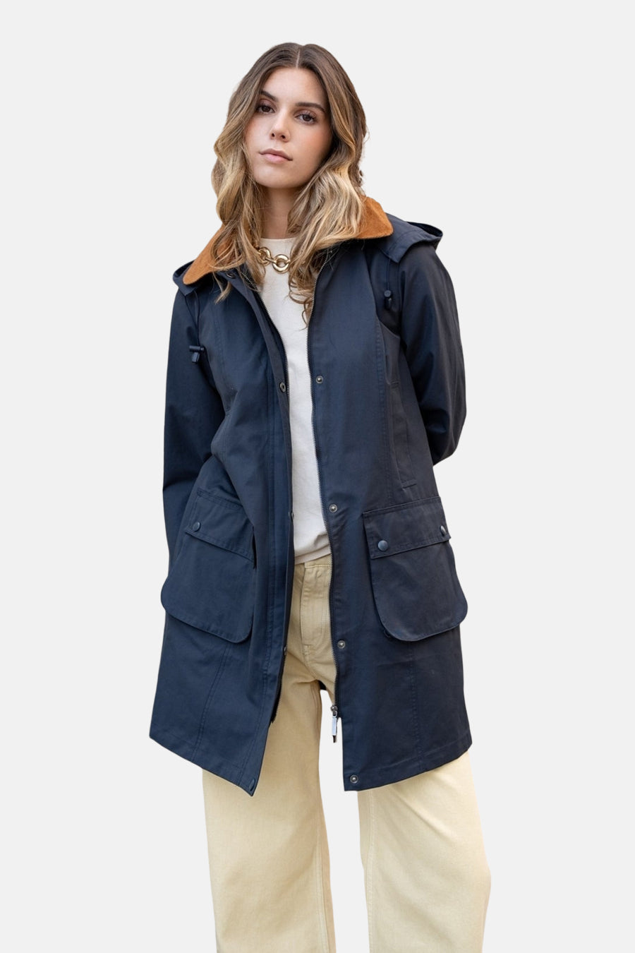 Blauwe regenjas van LAURA JO met bruine kraag, gedragen met een beige broek en een gouden ketting.
