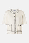 Gilet blanc de MORE & MORE, avec manches courtes, poches plaquées et bordure contrastante noire.
