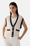 Gilet blanc, en maille ajourée de MORE & MORE, avec bordure bleu marine et boutons dorés.