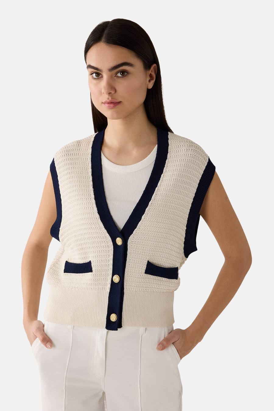 Gilet blanc, en maille ajourée de MORE & MORE, avec bordure bleu marine et boutons dorés.