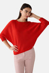 Pull rouge à col rond par MORE & MORE, avec des manches trois-quarts amples et un ourlet droit, porté avec un pantalon rose texturé.