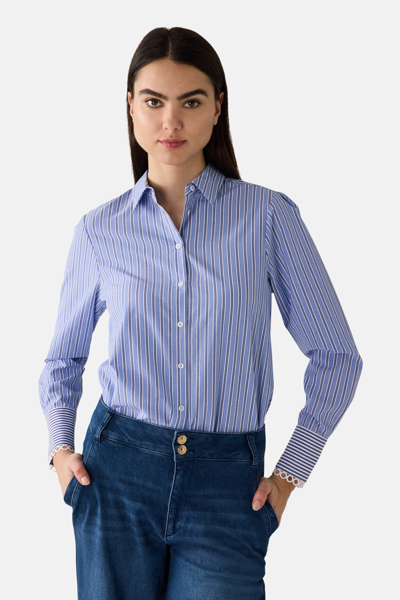 Blauwe gestreepte blouse van MORE & MORE, gedragen met een bedrukte sjaal en een wijde spijkerbroek.