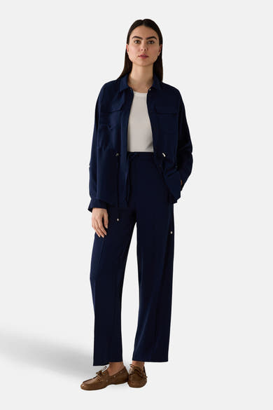 Pantalon de costume bleu de MORE & MORE, porté avec une chemise et des chaussures marron.